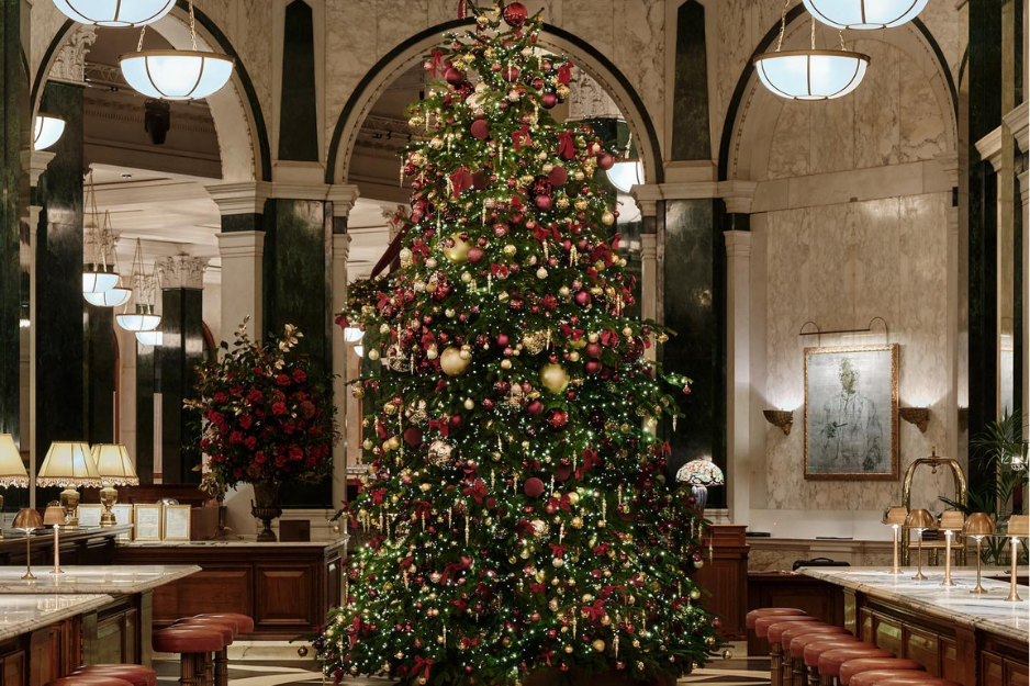 Towering Christmas tree and live music at The Ned London, one of the best hotels for London Christmas celebrations.