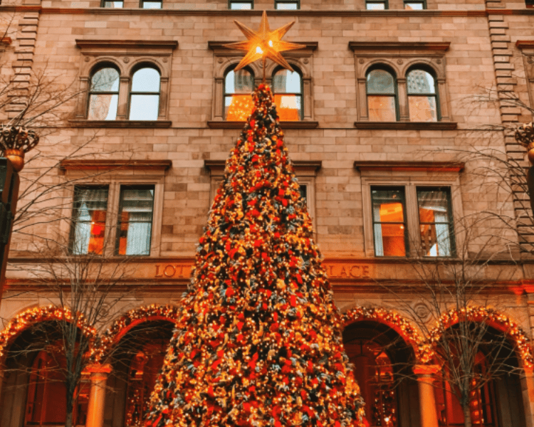 The Best Guide to Christmas in New York City 2025 The Lotte New York Palace courtyard Christmas tree glowing with festive lights, a top choice among New York City Christmas Hotels.