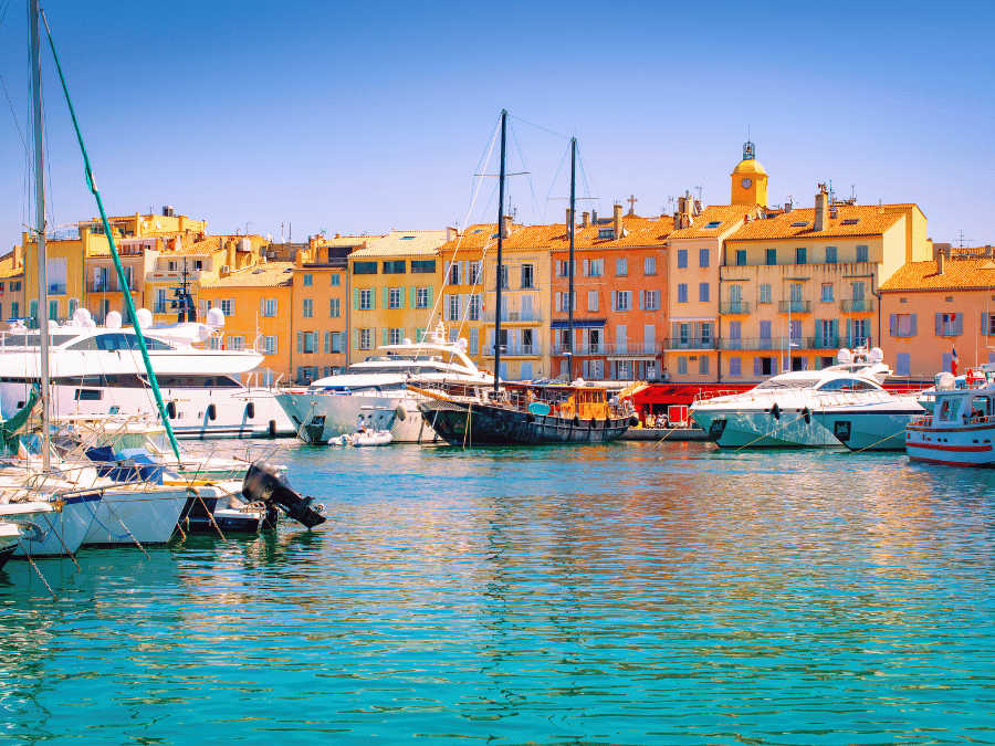 Saint Tropez yacht filled harbor with pastel buildingd, one of the best places to visit in the South of France for luxury and nightlife