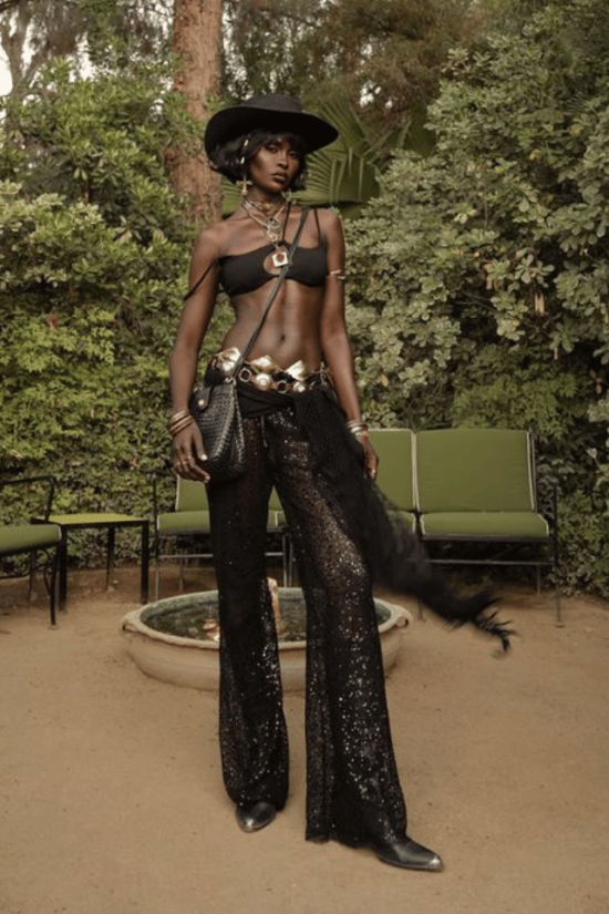 16 Country Concert Outfit Ideas woman in Country Concert Outfit Ideas with a black crop top and black pants with fringe