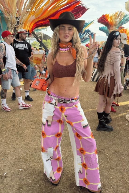 4 Country Concert Outfit Ideas woman in Country Concert Outfit Ideas with cowboy hat and graphic pink pants